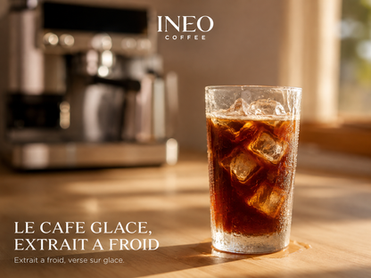 Café glacé préparé avec l'INEO Atelier, servi sur glace sur un plan de travail en chêne